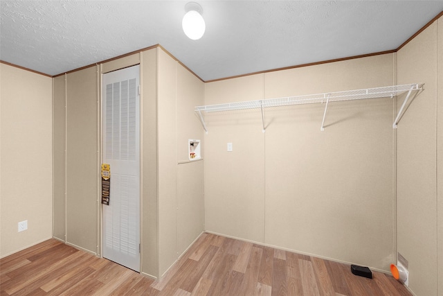 washroom with hardwood / wood-style floors, a textured ceiling, hookup for a washing machine, and ornamental molding