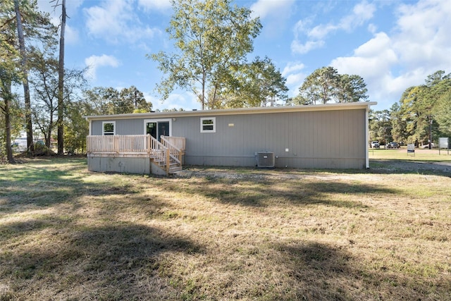 rear view of house with central AC, a yard, and a wooden deck