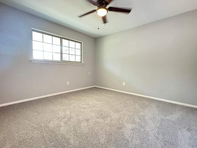 unfurnished room with ceiling fan and carpet