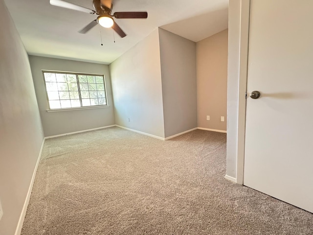 spare room with ceiling fan and light colored carpet