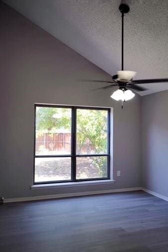 spare room featuring lofted ceiling, ceiling fan, dark wood-type flooring, and a textured ceiling