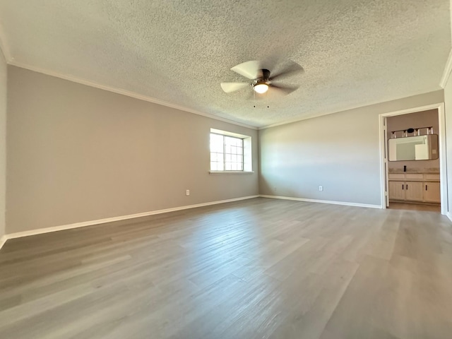 empty room featuring ceiling fan, crown molding, a textured ceiling, and hardwood / wood-style flooring