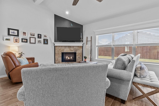 living room with ceiling fan, plenty of natural light, vaulted ceiling, and a fireplace