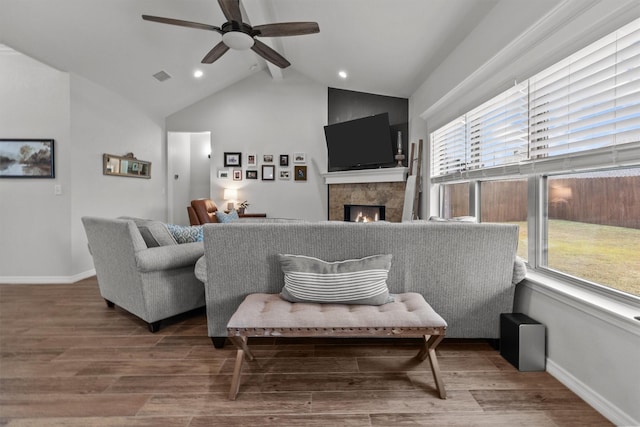 living room with ceiling fan, vaulted ceiling with beams, and hardwood / wood-style floors