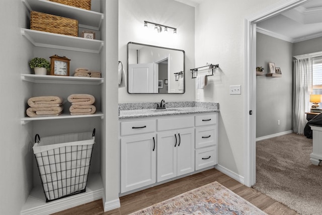 bathroom featuring vanity, ornamental molding, and hardwood / wood-style flooring