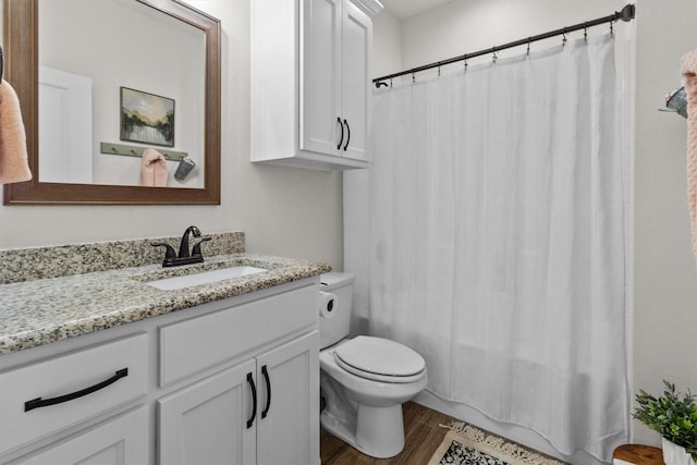 bathroom featuring toilet, hardwood / wood-style flooring, and vanity