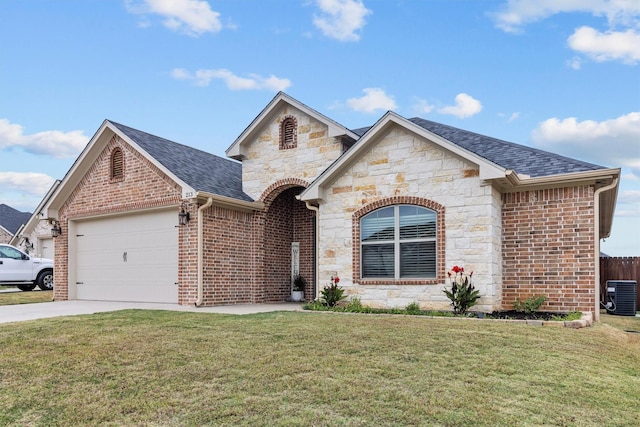 view of front facade with a front yard, central AC, and a garage