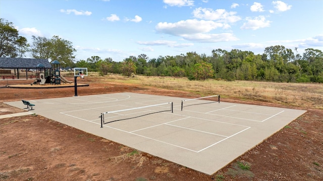 view of sport court featuring tennis court and a playground