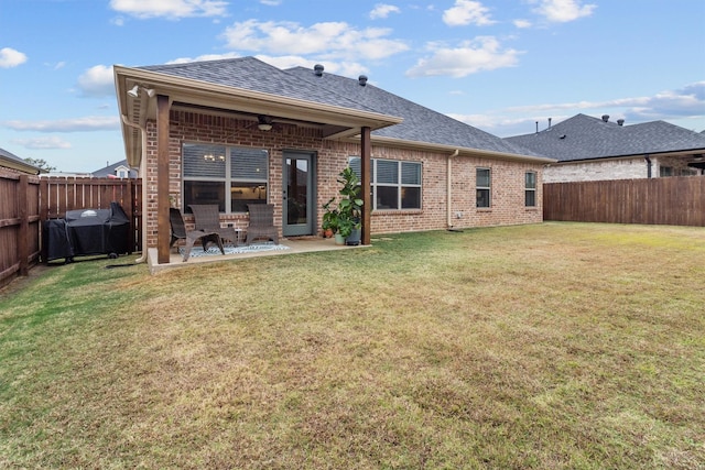 rear view of house featuring ceiling fan, a lawn, and a patio