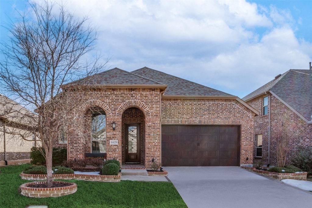 view of front of property with a front lawn and a garage