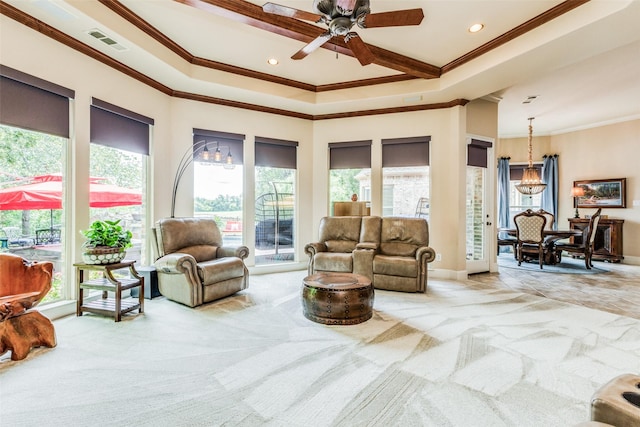 carpeted living room featuring a wealth of natural light, a tray ceiling, and ornamental molding