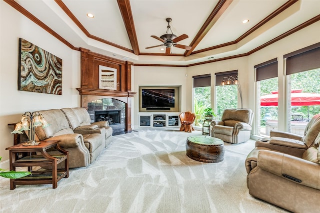 carpeted living room featuring beamed ceiling, a high end fireplace, a high ceiling, ornamental molding, and ceiling fan