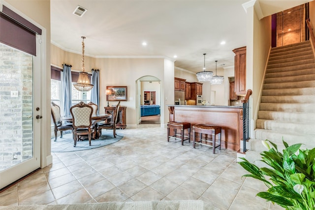 tiled dining space with crown molding and an inviting chandelier