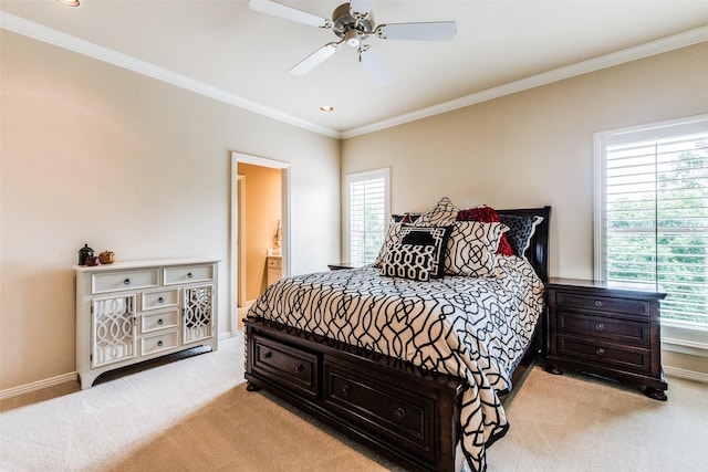 bedroom with multiple windows, light colored carpet, ensuite bath, and ceiling fan