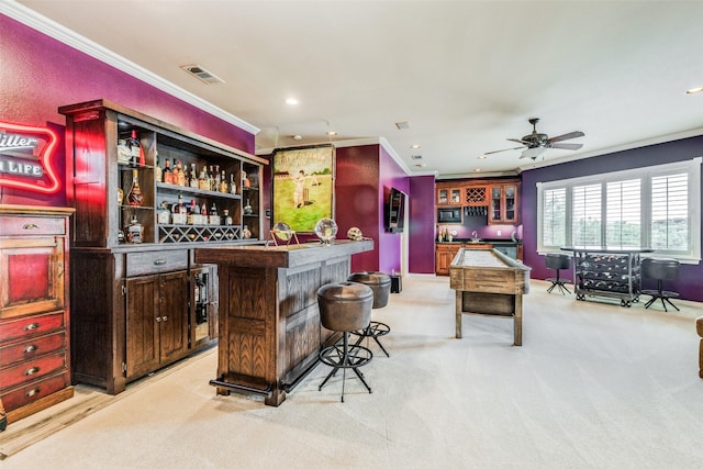 bar with ceiling fan, light colored carpet, and ornamental molding