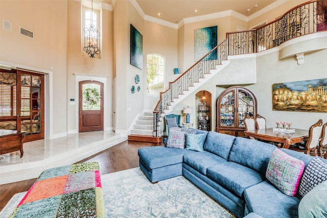 living room featuring plenty of natural light, a towering ceiling, and ornamental molding