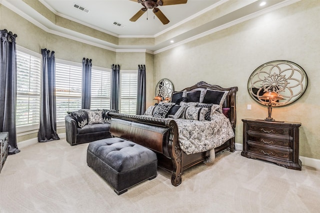 carpeted bedroom with ceiling fan, multiple windows, a tray ceiling, and crown molding