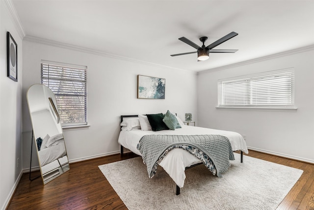 bedroom featuring crown molding, multiple windows, dark hardwood / wood-style floors, and ceiling fan