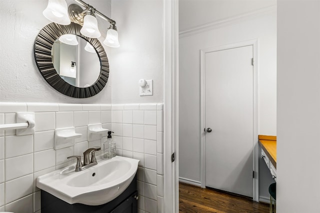 bathroom featuring vanity, hardwood / wood-style flooring, crown molding, and tile walls