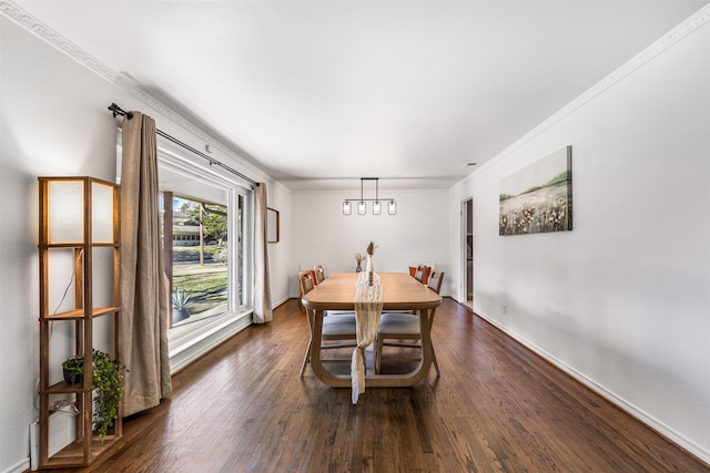 dining space featuring dark hardwood / wood-style floors, crown molding, and an inviting chandelier