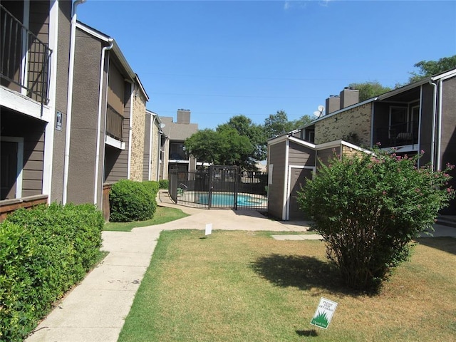 view of home's community featuring a swimming pool and a lawn