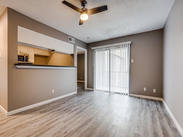 spare room featuring ceiling fan, a textured ceiling, and light hardwood / wood-style floors