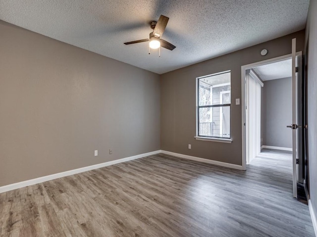 unfurnished room with wood-type flooring, a textured ceiling, and ceiling fan