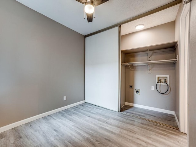 laundry room with washer hookup, a textured ceiling, light hardwood / wood-style floors, and hookup for an electric dryer