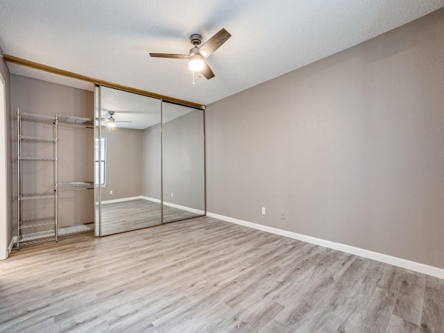 unfurnished bedroom with a textured ceiling, ceiling fan, a closet, and light hardwood / wood-style floors