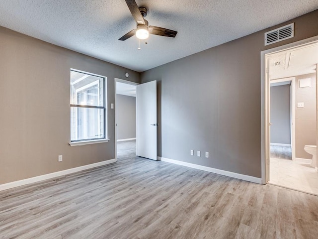 spare room featuring light hardwood / wood-style floors, a textured ceiling, and ceiling fan