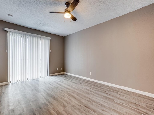 spare room with ceiling fan, light wood-type flooring, plenty of natural light, and a textured ceiling