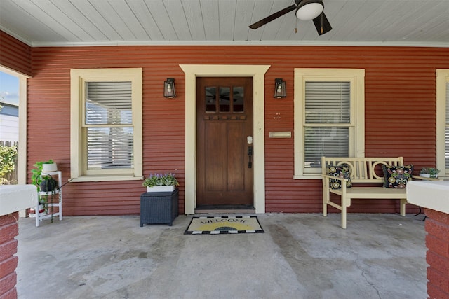 view of exterior entry with ceiling fan and covered porch