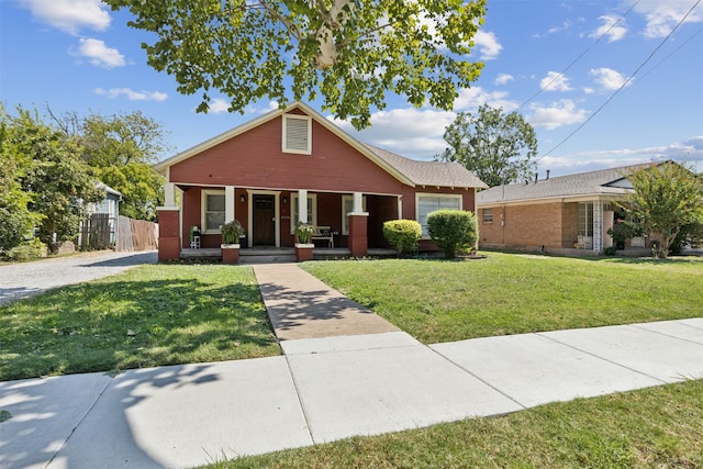 bungalow-style home with a front lawn, a garage, and a porch