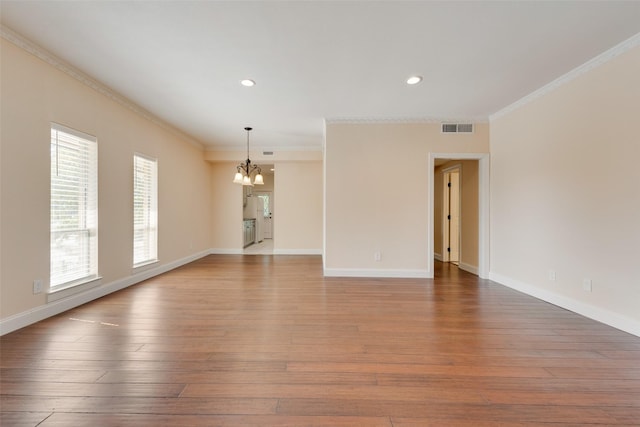 unfurnished room with a wealth of natural light, a chandelier, and ornamental molding