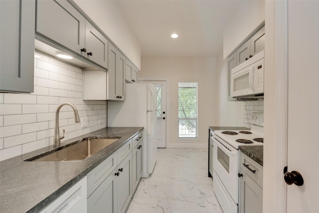 kitchen featuring gray cabinetry, backsplash, sink, and white appliances