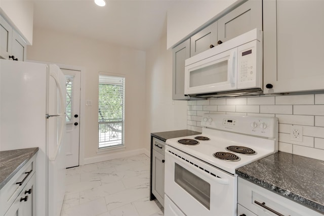 kitchen featuring white appliances, dark stone countertops, and tasteful backsplash