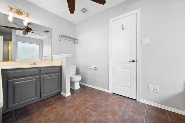 bathroom with vanity, ceiling fan, toilet, and a textured ceiling