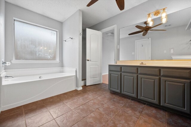 bathroom featuring ceiling fan, vanity, a bath, and a textured ceiling