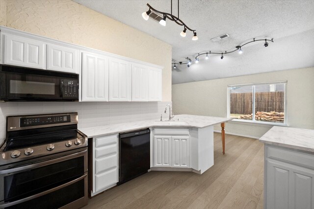 kitchen featuring white cabinetry, lofted ceiling, a textured ceiling, and a kitchen island