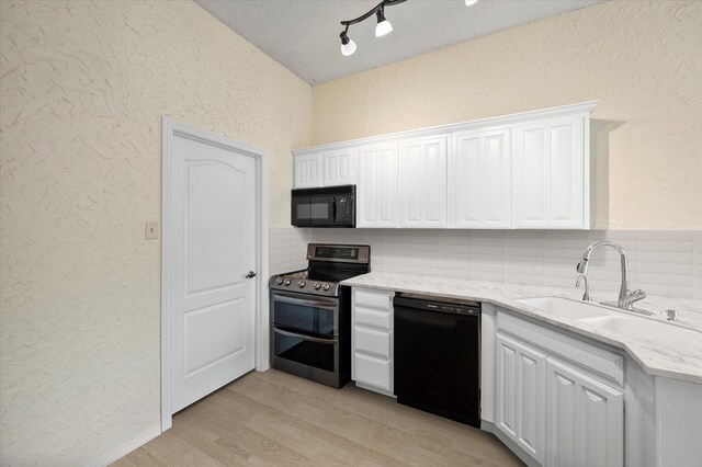 kitchen featuring sink, kitchen peninsula, white cabinets, and black appliances