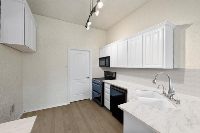 kitchen with white cabinetry, sink, decorative backsplash, and black appliances