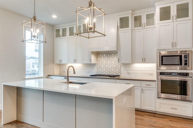 kitchen featuring sink, hanging light fixtures, appliances with stainless steel finishes, and white cabinets