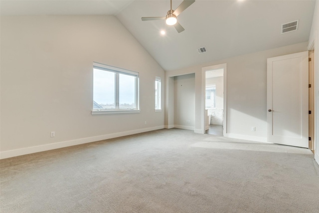 carpeted spare room with ceiling fan and high vaulted ceiling