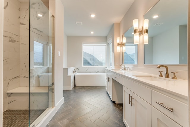 bathroom with vanity and shower with separate bathtub