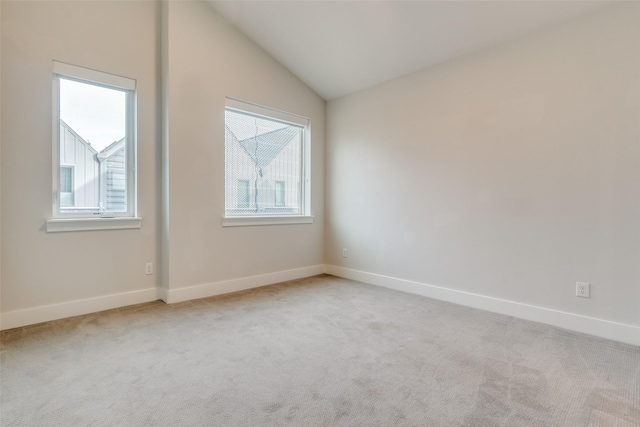 carpeted spare room featuring lofted ceiling