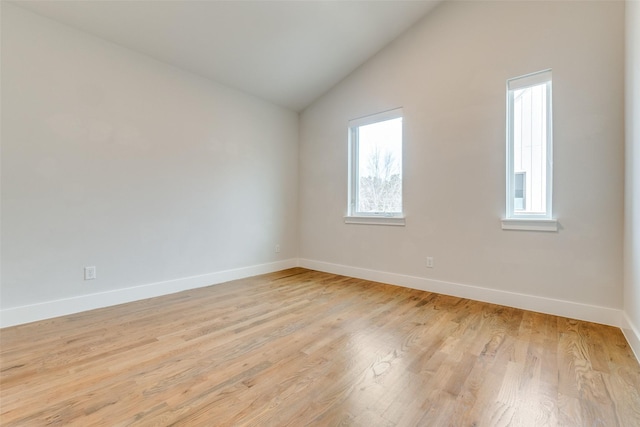 spare room featuring light hardwood / wood-style floors and vaulted ceiling