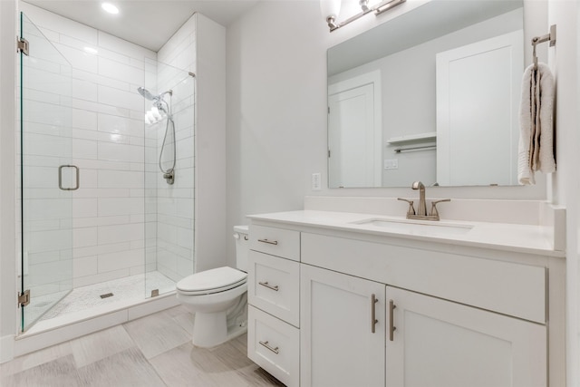 bathroom featuring toilet, walk in shower, and vanity