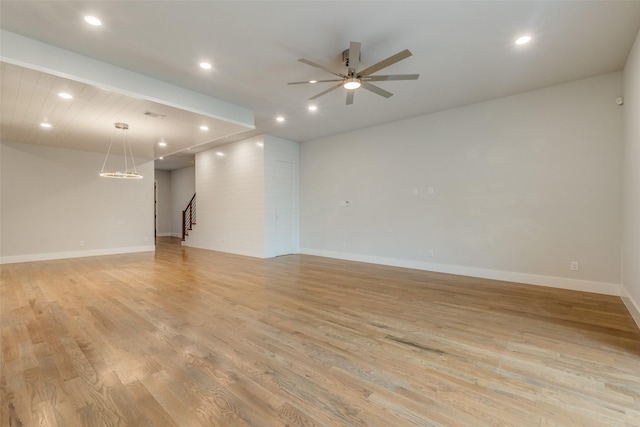 empty room with ceiling fan and light hardwood / wood-style flooring