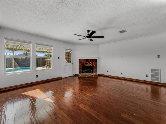 unfurnished living room featuring a brick fireplace, hardwood / wood-style floors, a textured ceiling, and ceiling fan