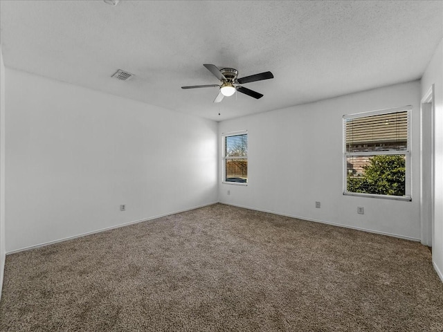 carpeted spare room with a textured ceiling and ceiling fan